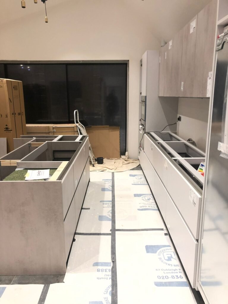 New kitchen carcass being installed, wall units being hung and centre island erected