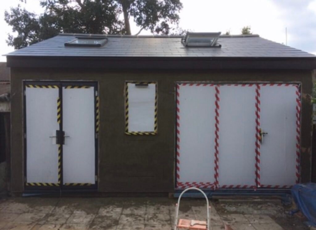 Front of outbuilding having sand and cement rendered